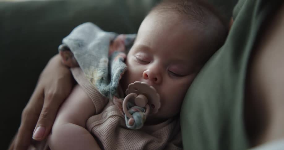 A woman holds her sleeping baby