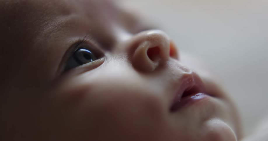 Baby works their mouth and stares up