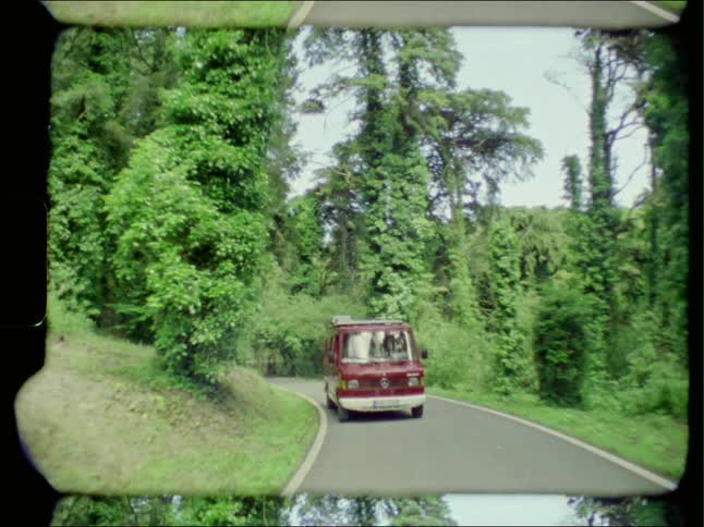 Vintage footage of a van driving down a road