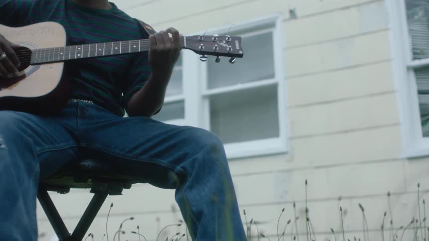 A man playing a guitar outside