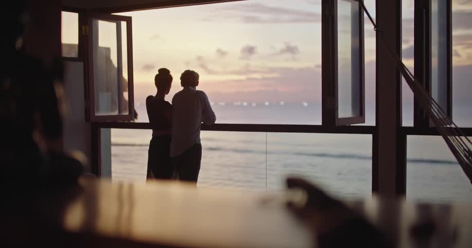 A couple watch the sunrise from the window