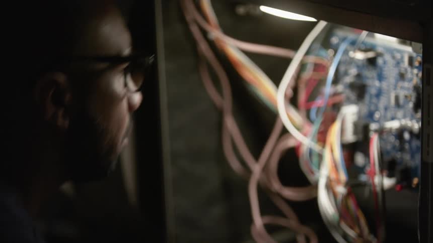 A man opens the back of a data server to check cables