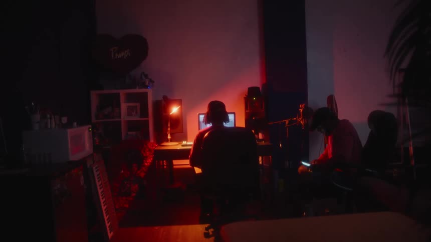 Two men sit in the studio together by the computer