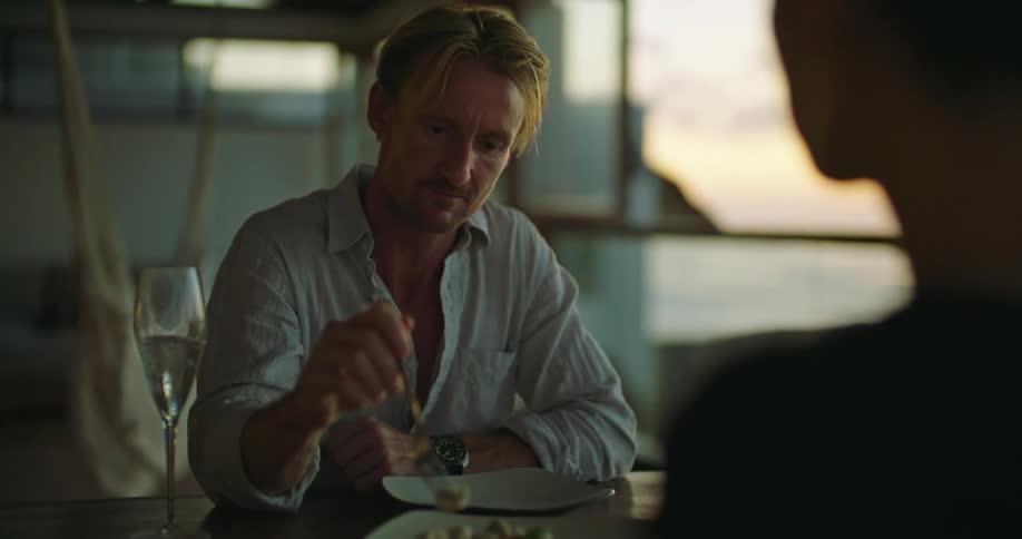 A couple eat food together and talk