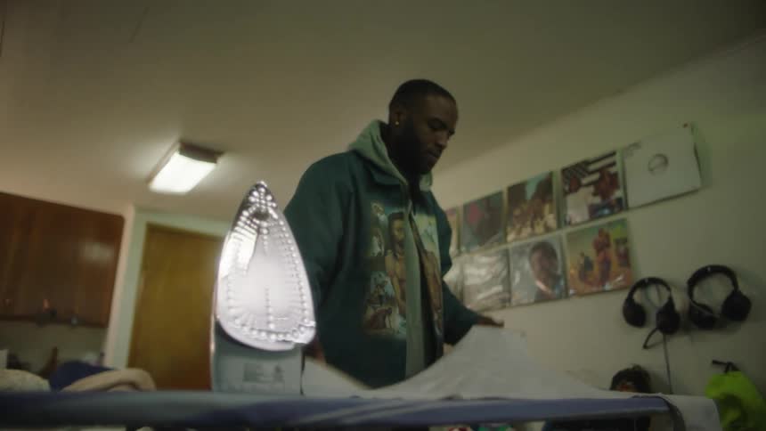 A man ironing clothes in a house
