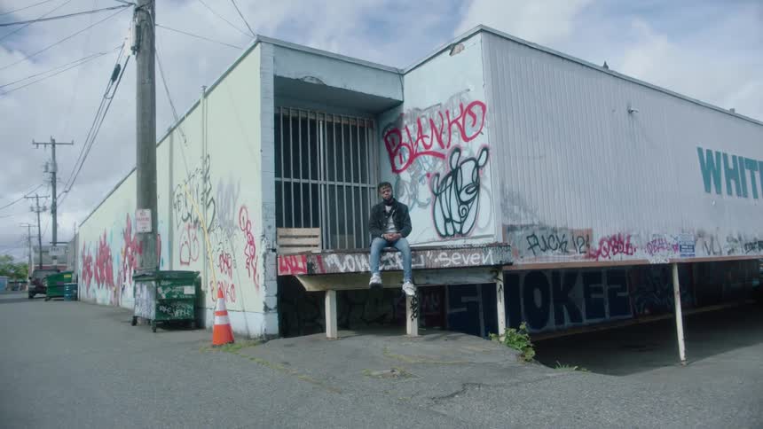 A man sits in front of the building