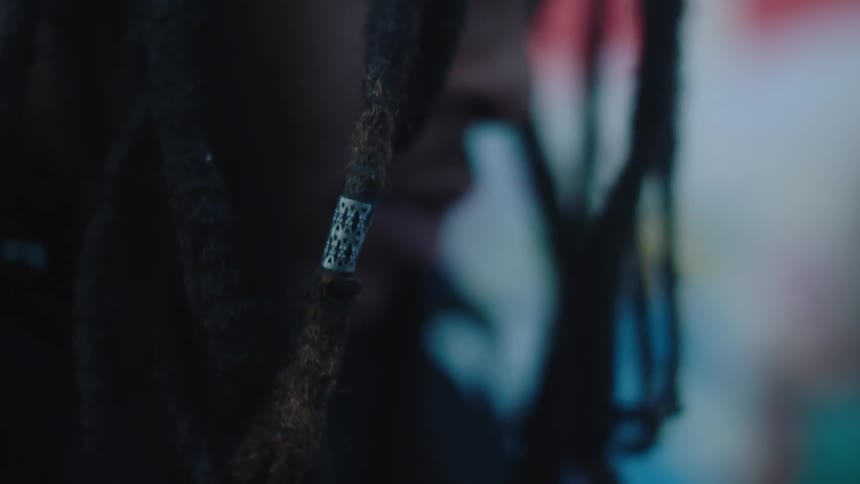 A mans hair hangs in front of his face as he nods his head to music