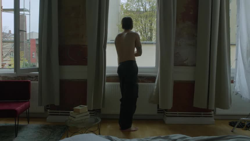 A man is standing by the window