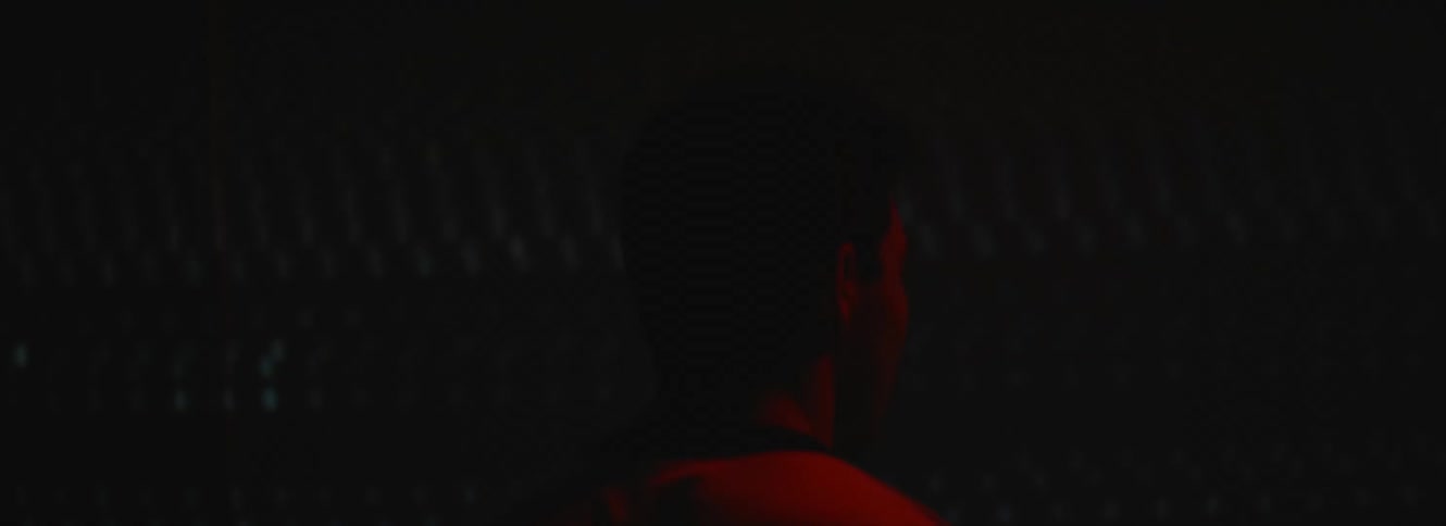 A man walks up to and touches a projection screen playing video of static