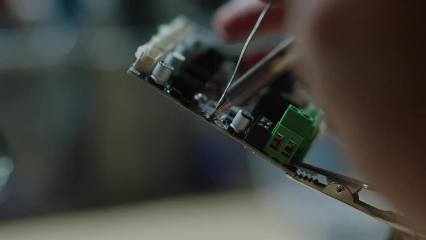 A person is soldering a computer board