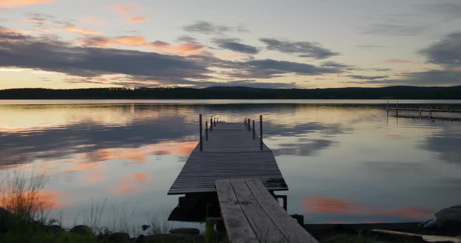 Pier in calm lake at dusk