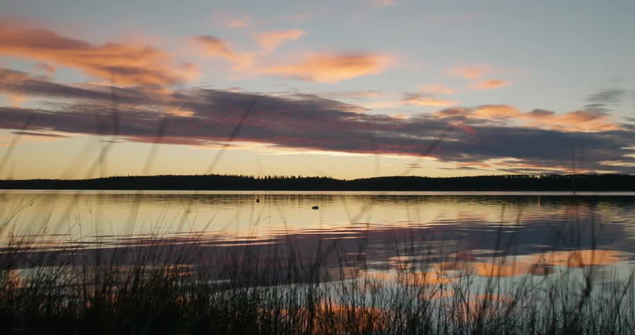 The sun is setting in the horizon over a body of water