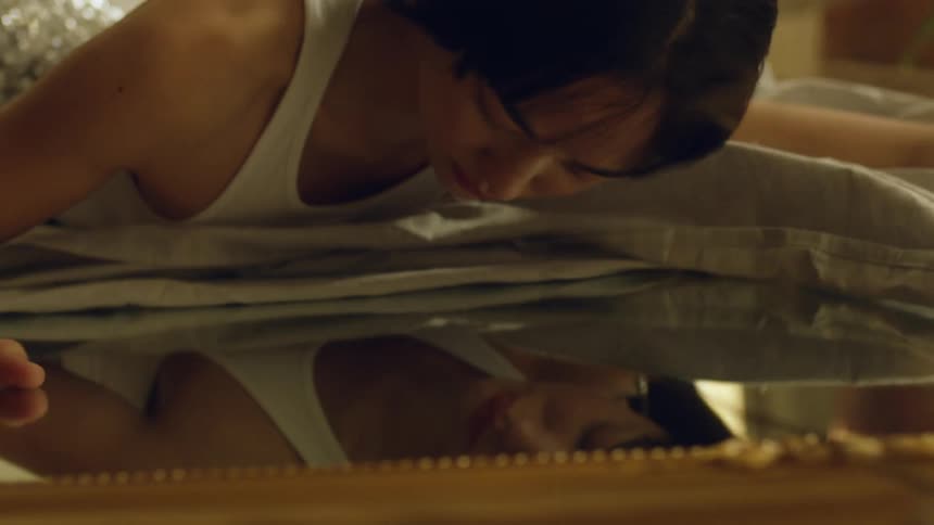 A woman is looking into the mirror