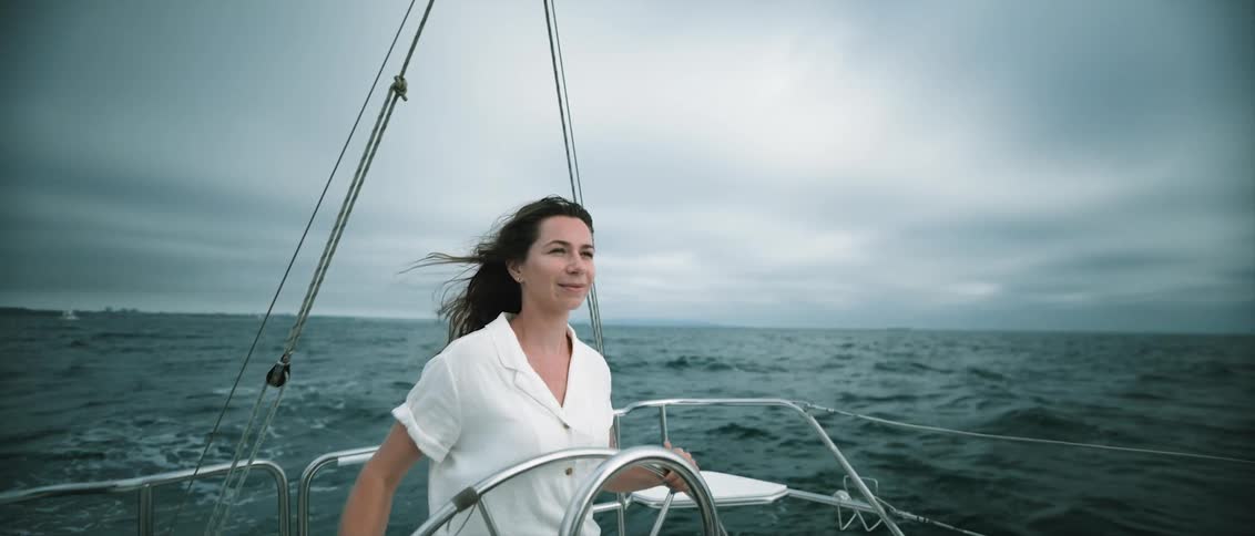 A woman is driving a boat through ocean water