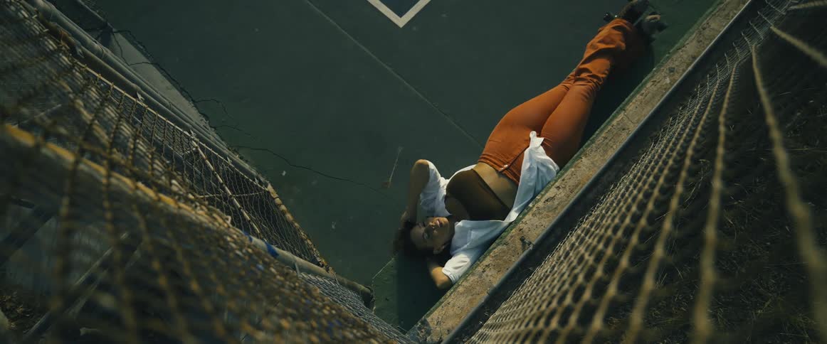 A woman relaxes on a bench at the basketball court