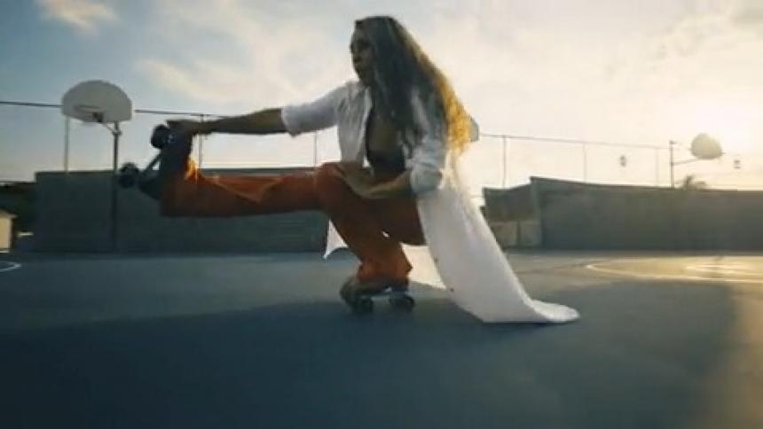 A woman roller skating does a trick dance move