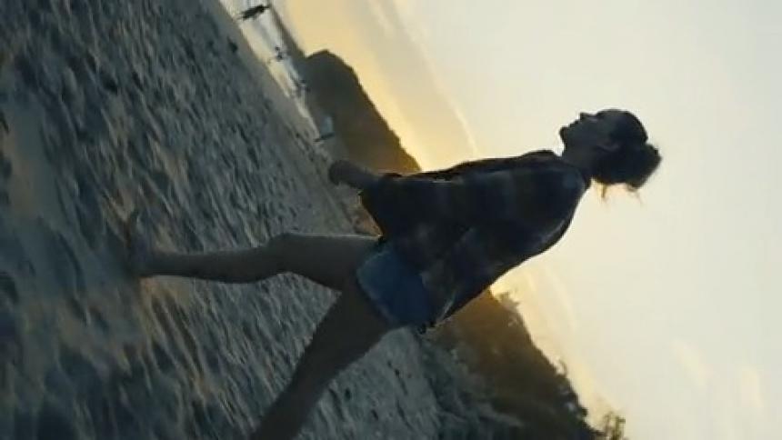 A woman walks towards the water on the beach