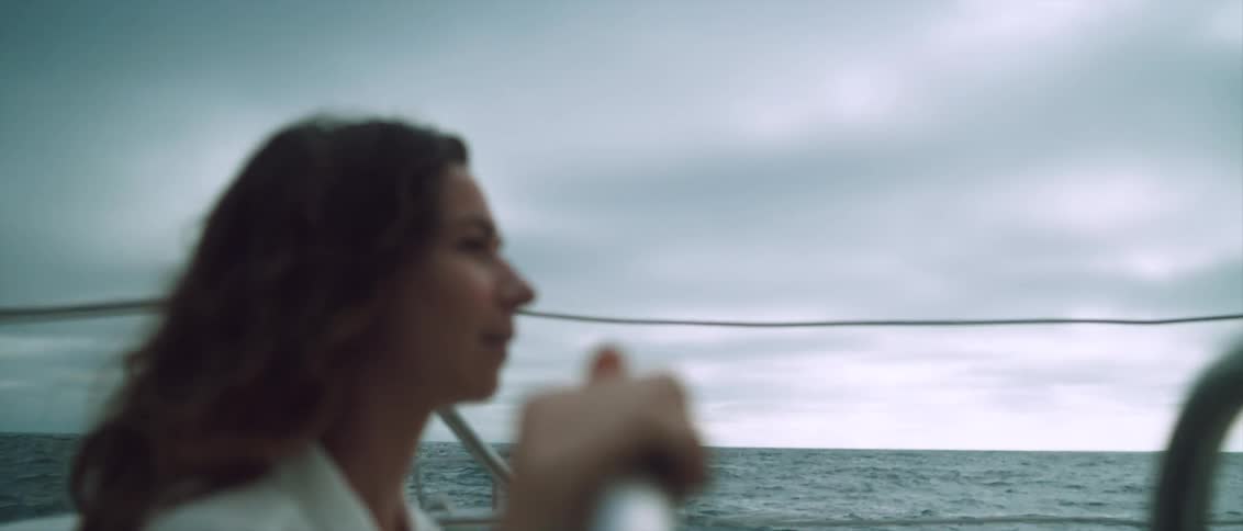 Woman pilots a sailboat on a stormy day