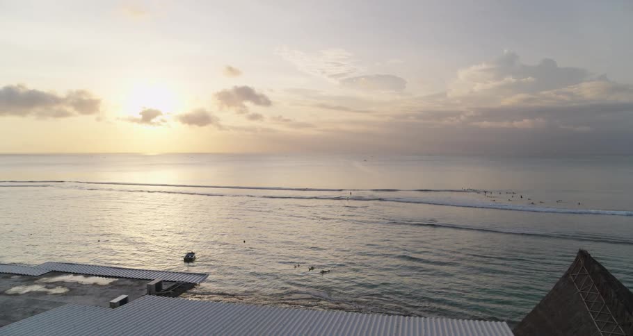 Looking out a window reveals a beach and waves