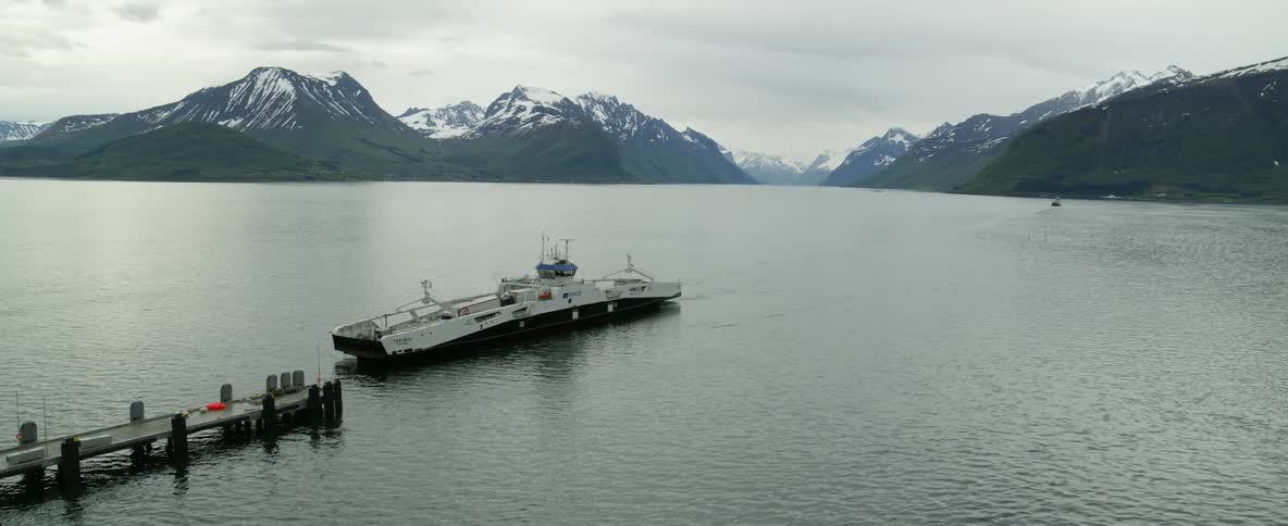 Aerial view of a ferry approaching a dock in Norwegian fjords