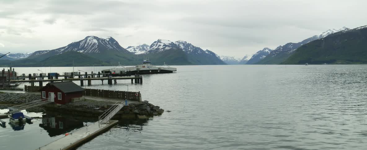 A boat is in the ocean water near the pier