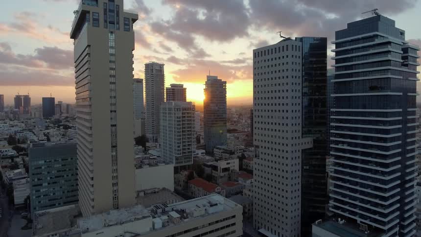Skyscrapers stand tall against a sunset