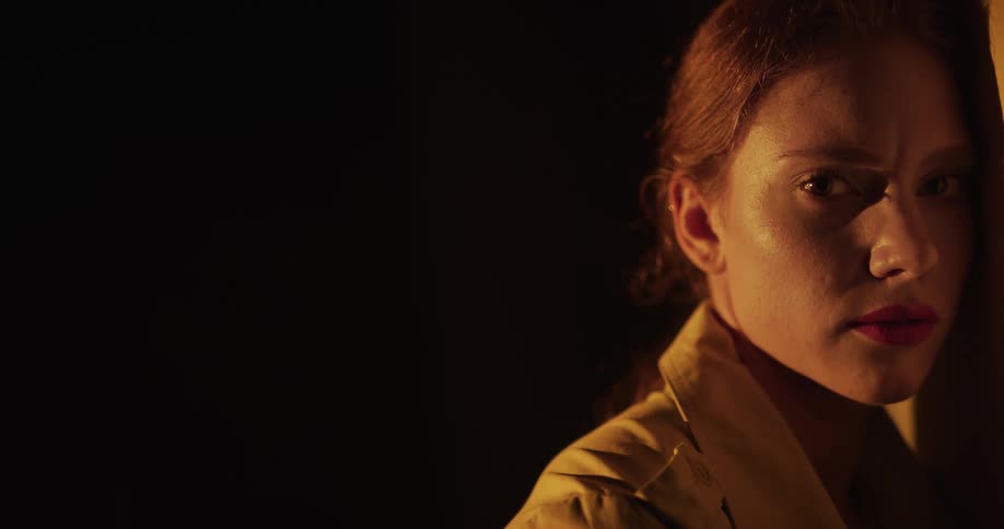 A woman is standing outdoors during the night