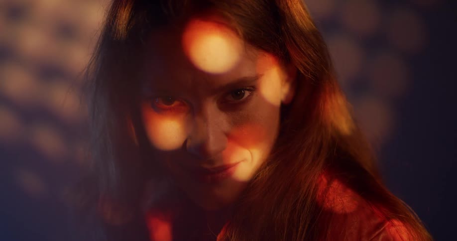 A woman outside smiles and then closes her eyes