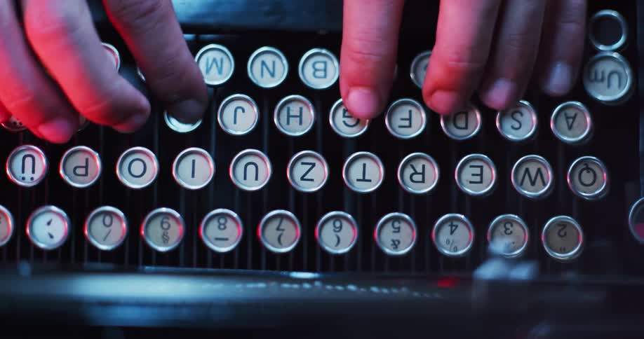 Hands of a man typing on a typewriter