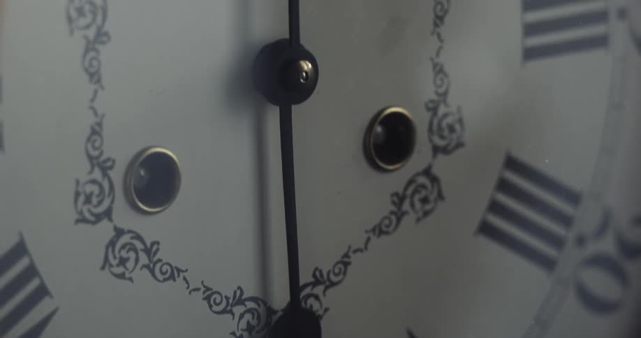 The hands of an analog clock cast a shadow on the clock face
