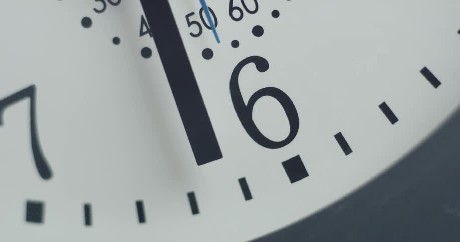 The big hand of an analog clock is just past the number six