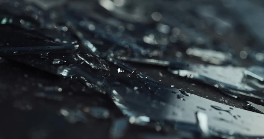 Wet shards of glass are covering the ground outside