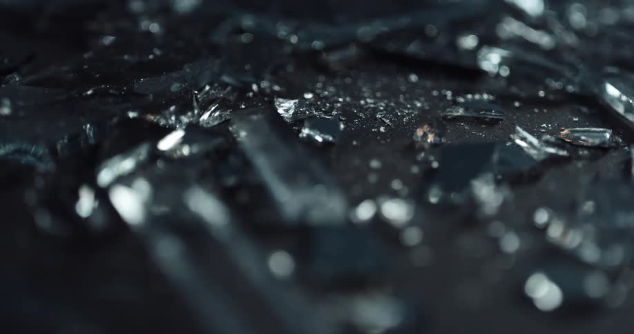 Close up of broken glass with police lights displaying on