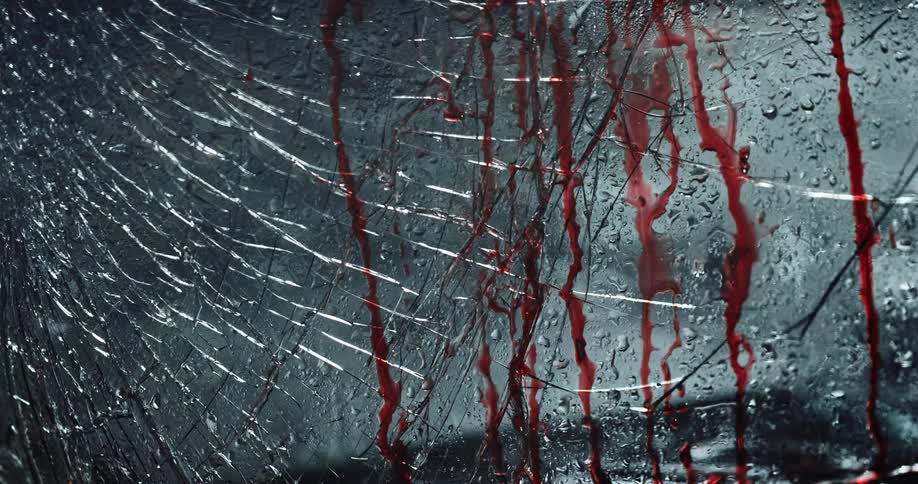 Red lights are flashing upon shattered glass as blood drips down
