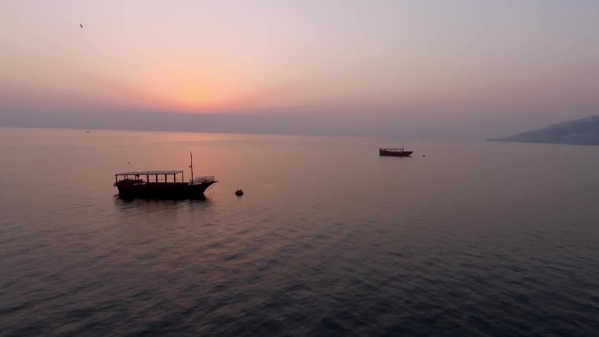 Boats in a body of water at sunset