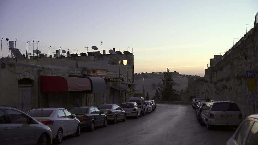 A car lined street at sunset