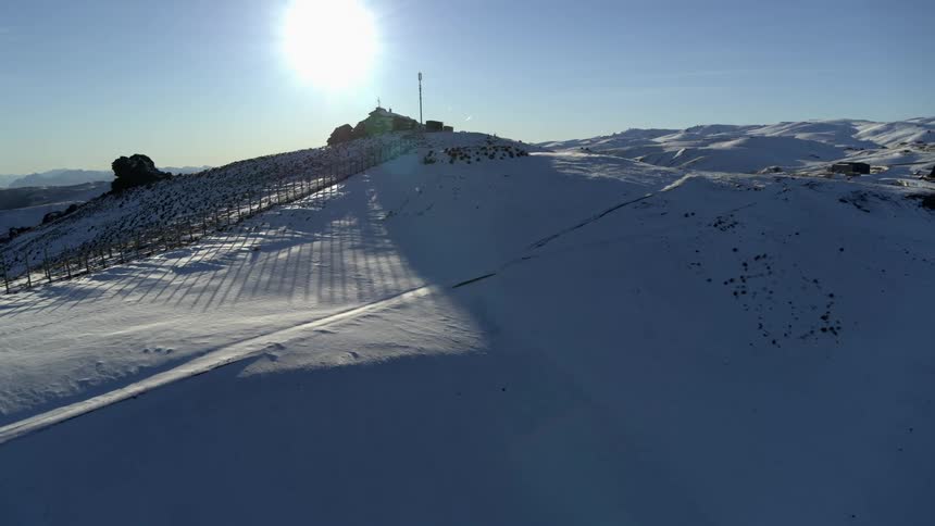 A building sits on top of a snowy mountain