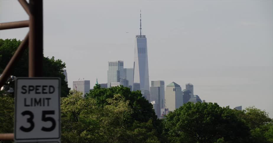 One world trade center standing tall in the city skyline as an airplane passes behind it