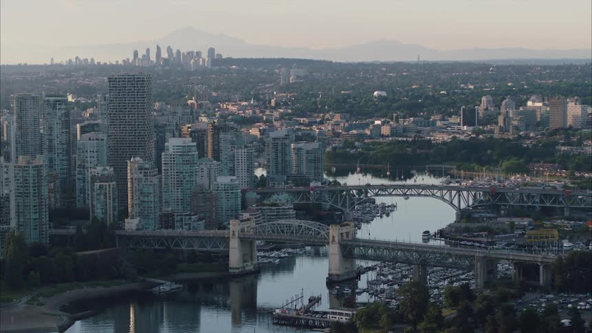 An aerial view of high rise office buildings by a river in a city