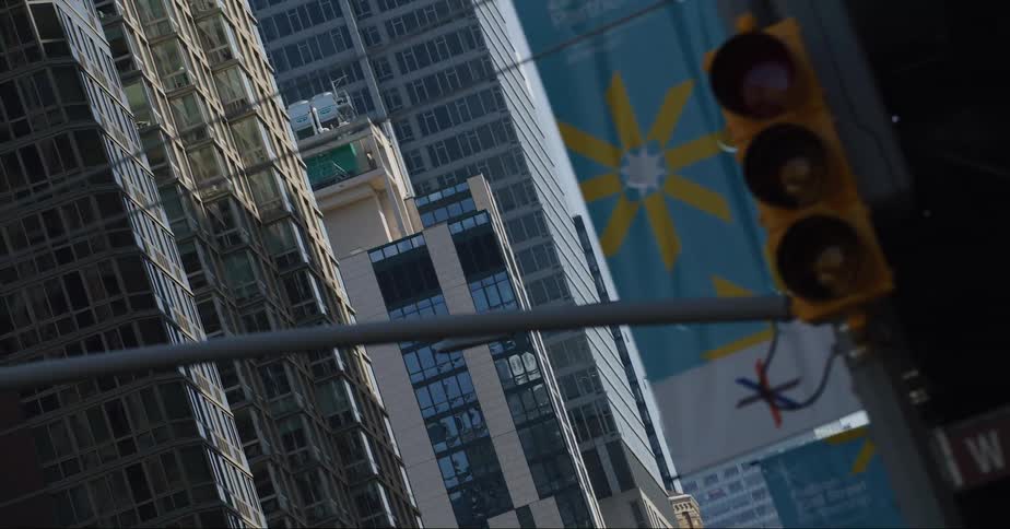 Traffic light flashes a yellow arrow at corner of downtown skyscrapers