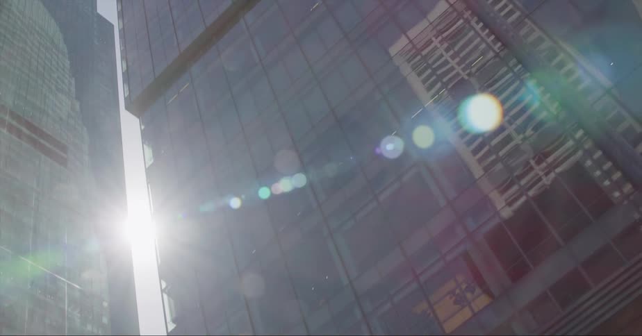 Slow motion footage of the facade of tall skyscrapers in the city seen from a moving vehicle