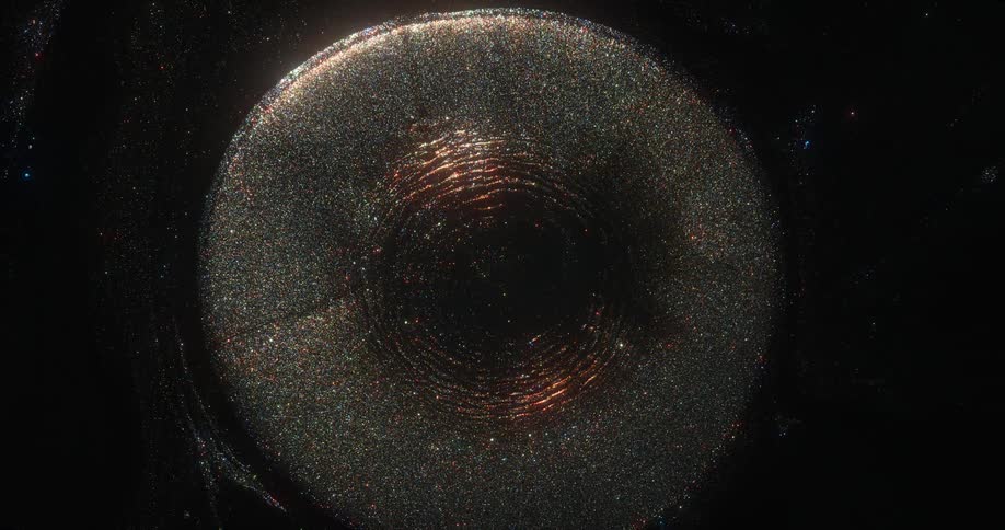 An orb of golden glitter emerges from the darkness and sparkles as it grows