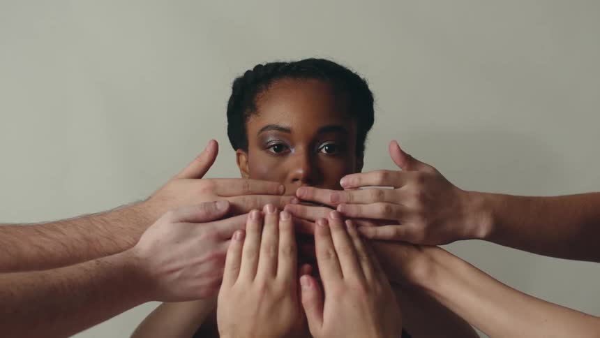 Hands covering the face of a woman face retract to reveal her decorated lips