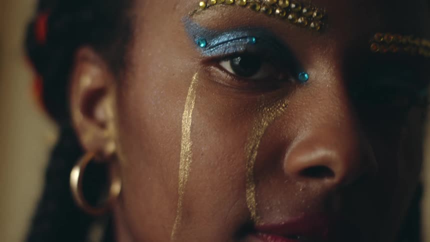 Close up of the face of a woman with colorful decorative makeup