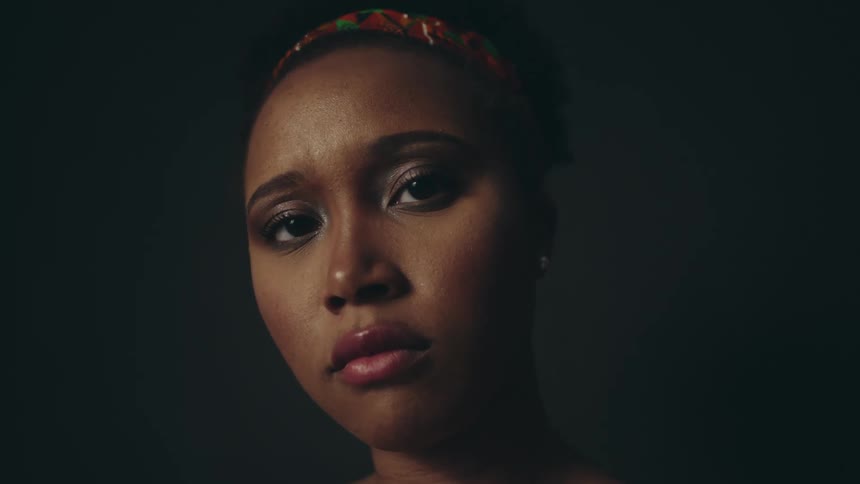 Close up portrait of a black woman inside a dark room