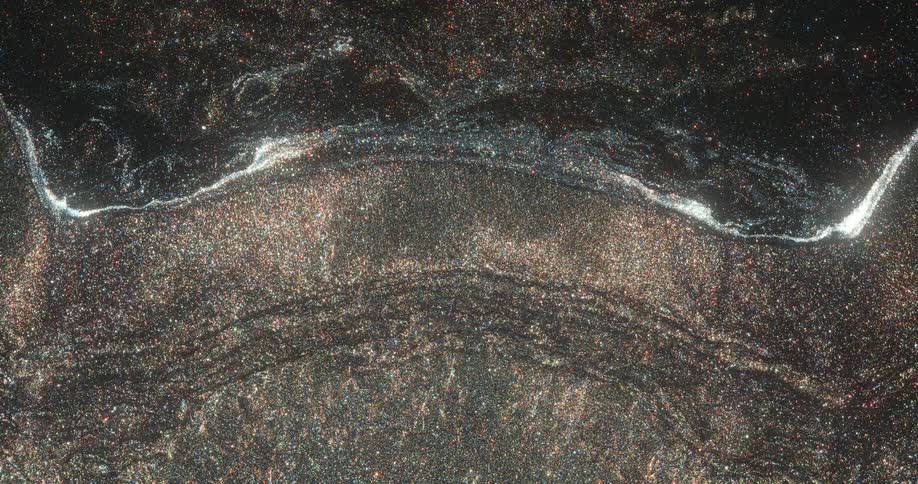 Dark sand glimmers in sunlight