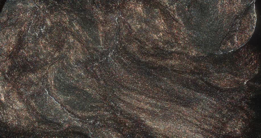 Shiny pulsating clouds or waves of vibrating glittering brown particles flowing inwards