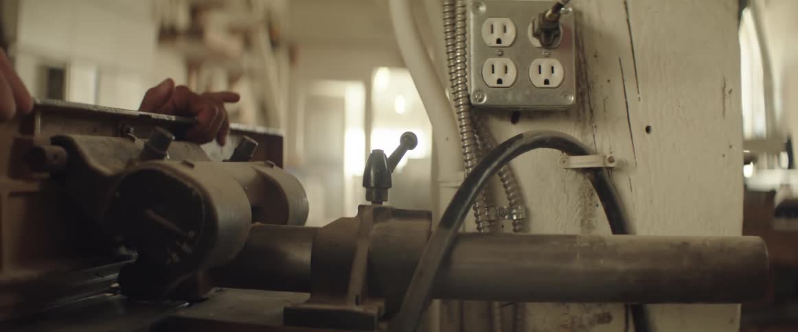 Man fastens the levers on a machine inside a workshop