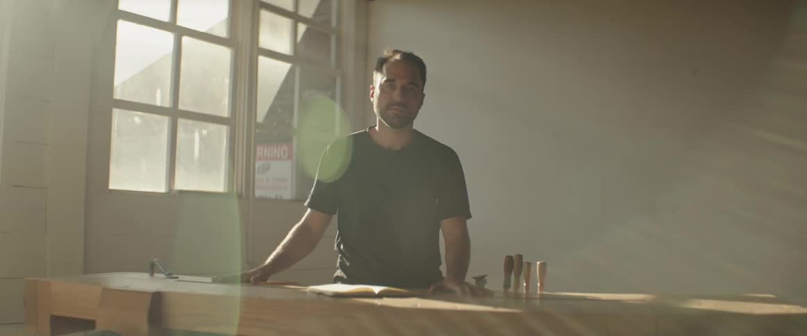 Portrait of a man standing at a table with an open book
