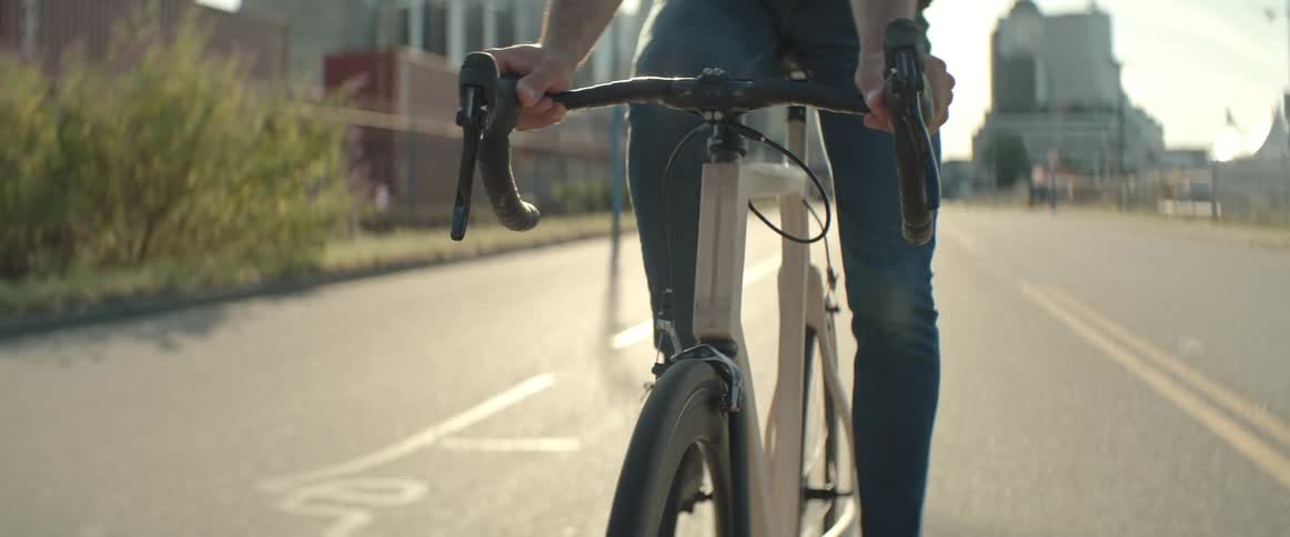 A person rides a bike on a quiet roadway near a large city